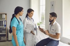 paciente-joven-hablando-con-un-médico-y-una-enfermera-en-la-clínica-durante-visita-hombres-j...jpg